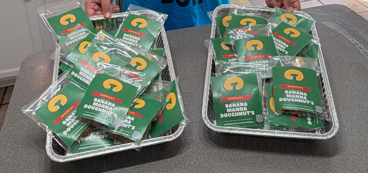 Two trays full of freshly bagged banana manna doughnuts in a home kitchen